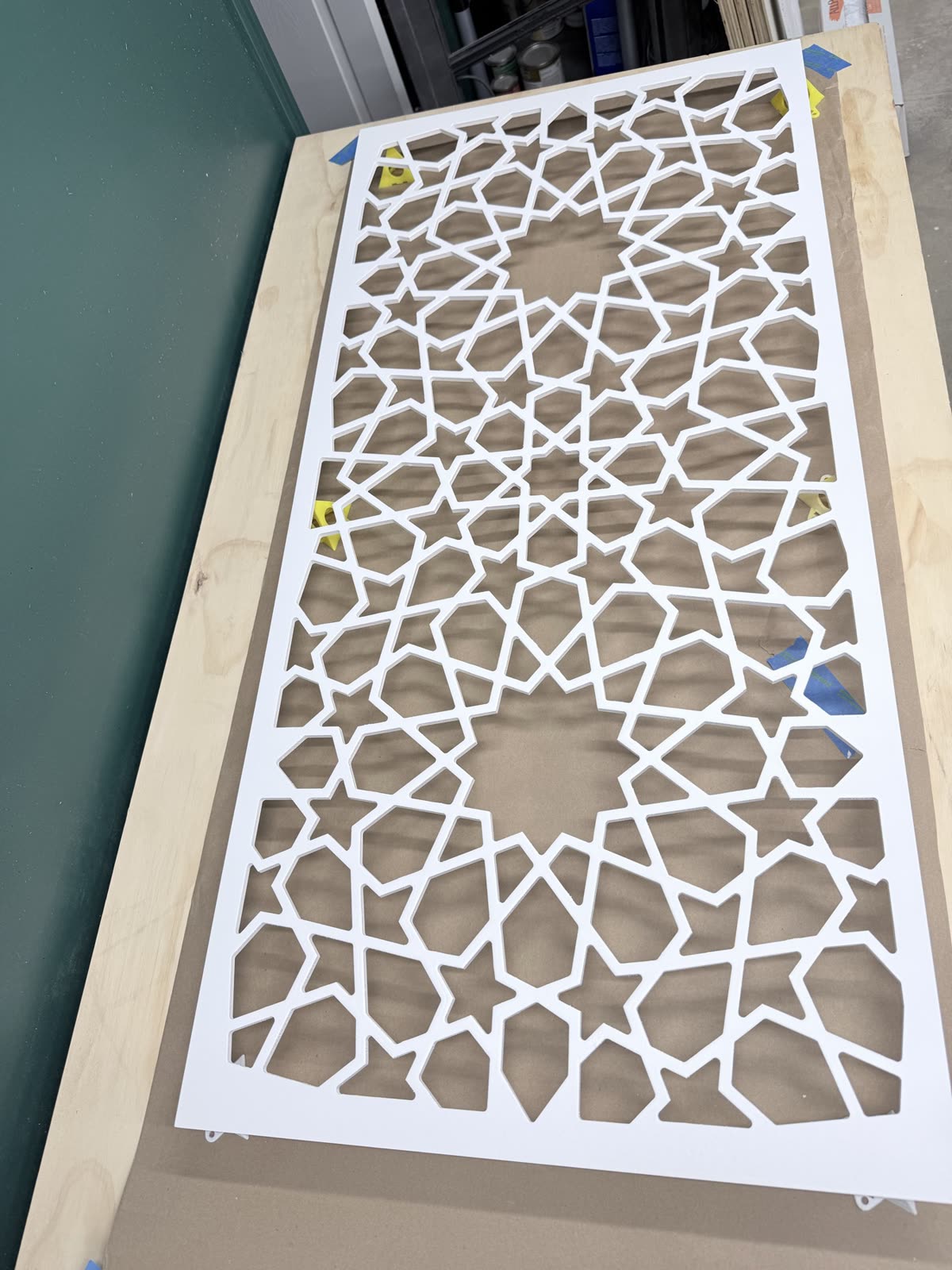 A freshly cut white lattice panel lying on the workshop bench