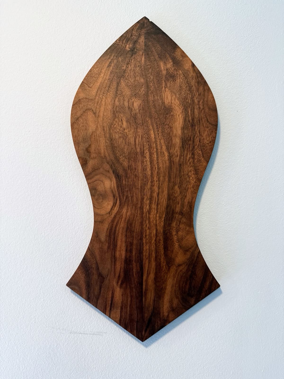 Nalayn Shareef in walnut, straight on against a plain wall
