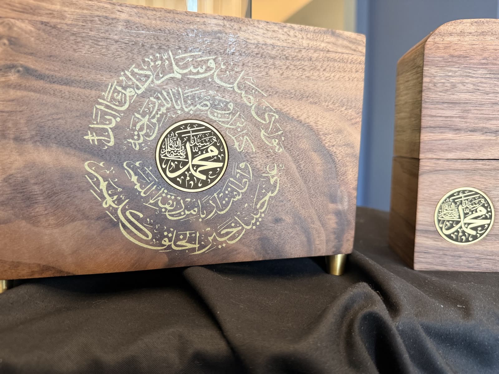 Close-up of a hand-finished walnut box with gold-filled calligraphy